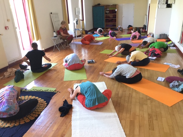 Photo de pratiquants de yoga en posture assise avec étirement latéral